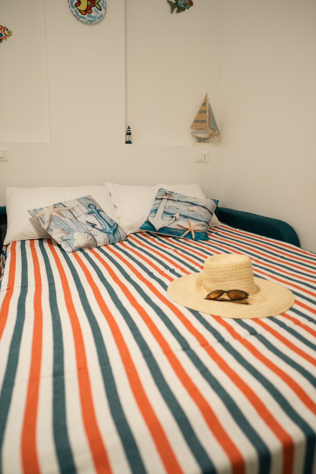 Casa Asia, divano letto con copriletto a righe colorate