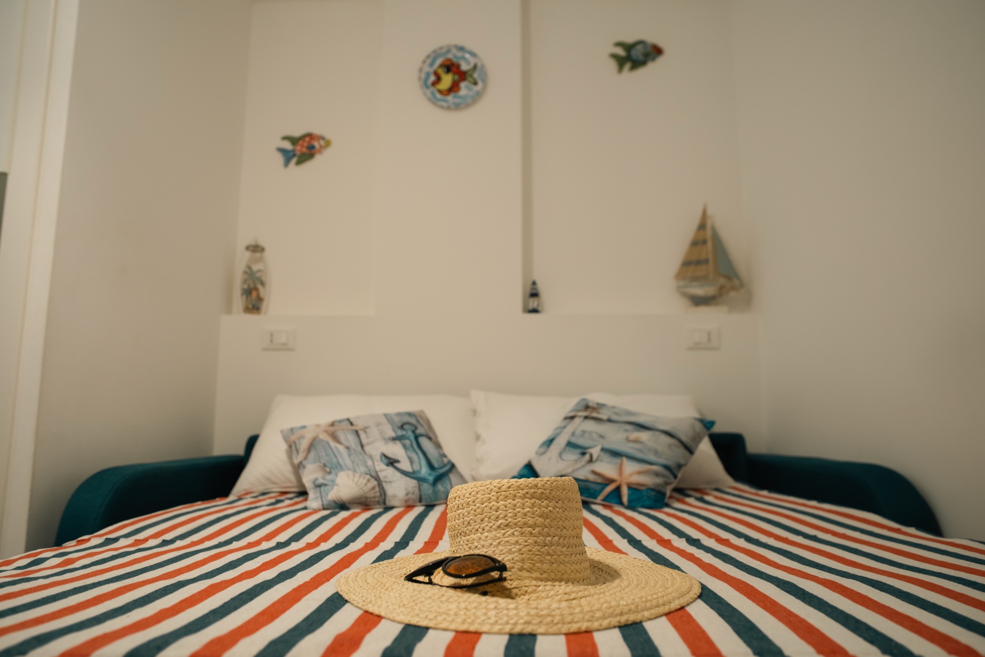 Casa Asia, divano letto con pesci in ceramica alla parete