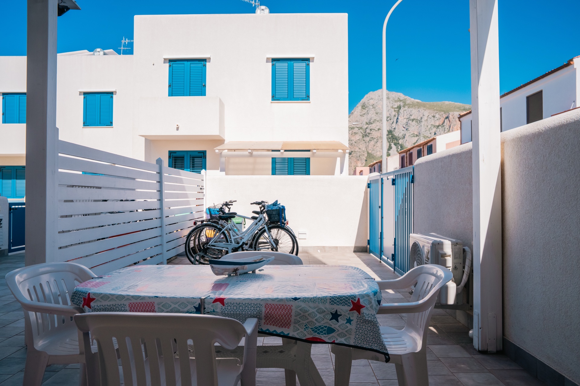 Veranda esterna con tavolo, sedie e bici sullo sfondo e vista sul Monte Monaco