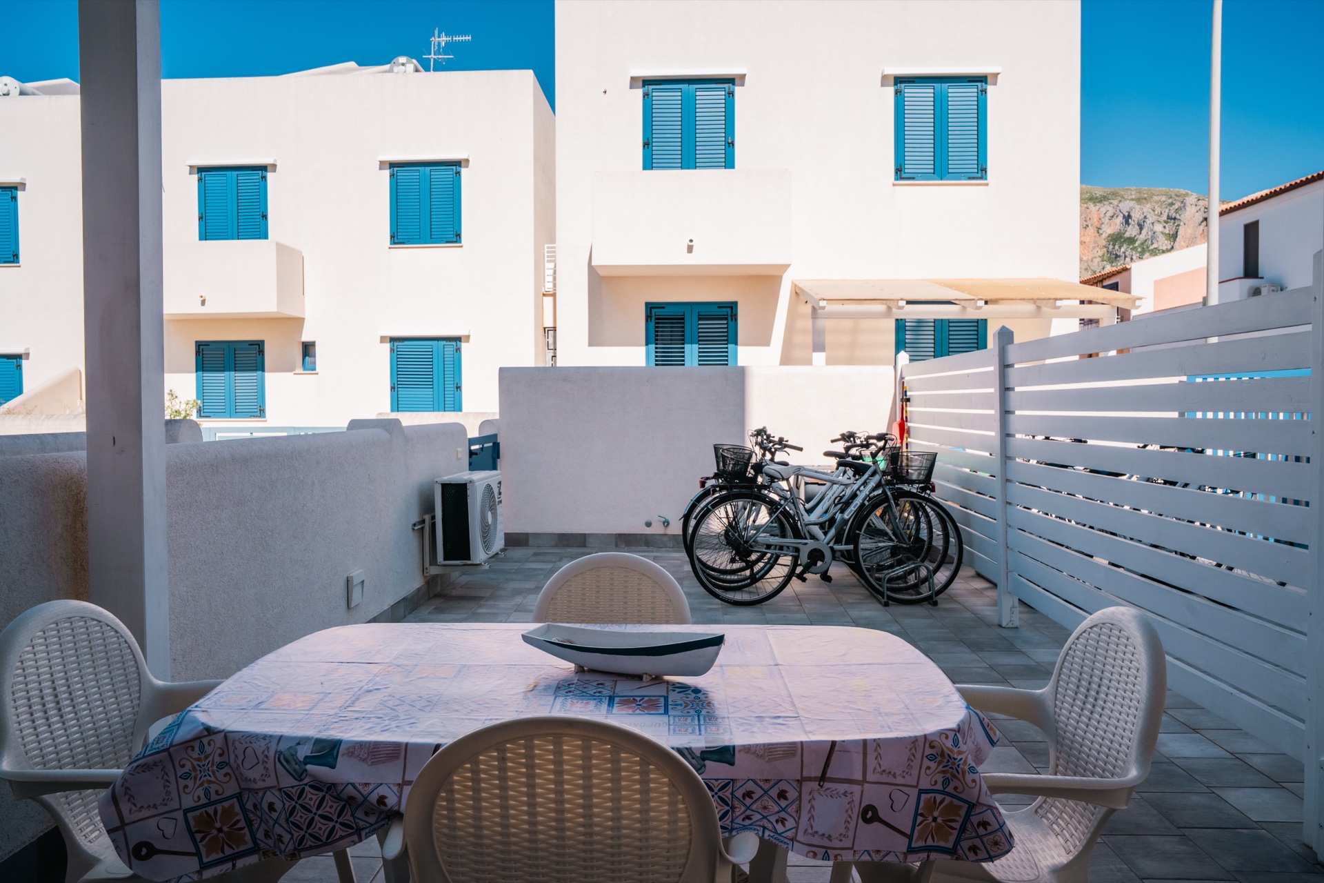 Tavolo della veranda con bici parcheggiate e vista sulle case bianche