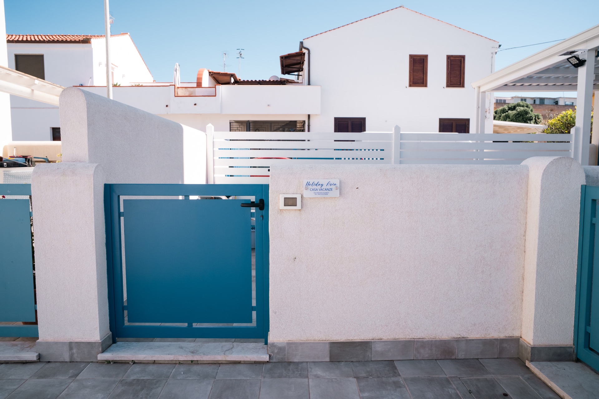 Cancello d'ingresso blu di Holiday Asia con targa Casa Vacanze