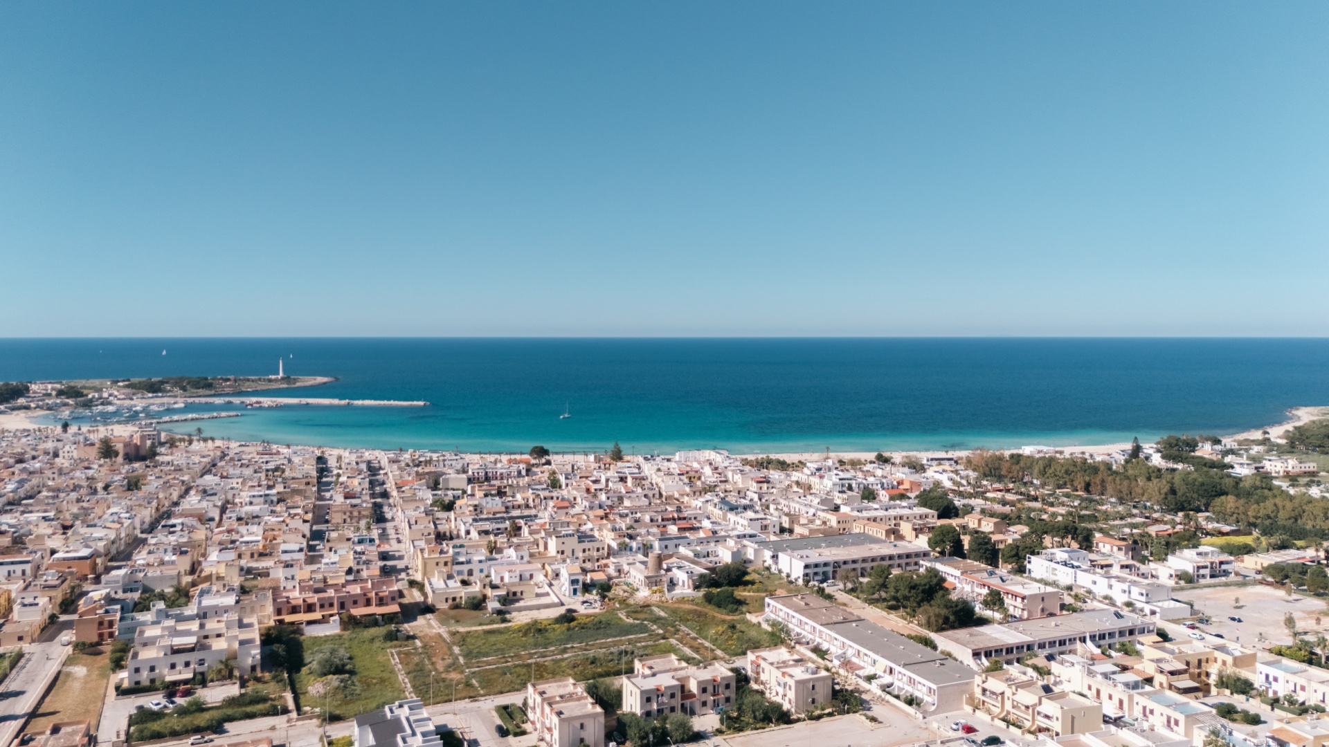 Vista aerea di San Vito Lo Capo con il centro abitato, la spiaggia e il mare aperto