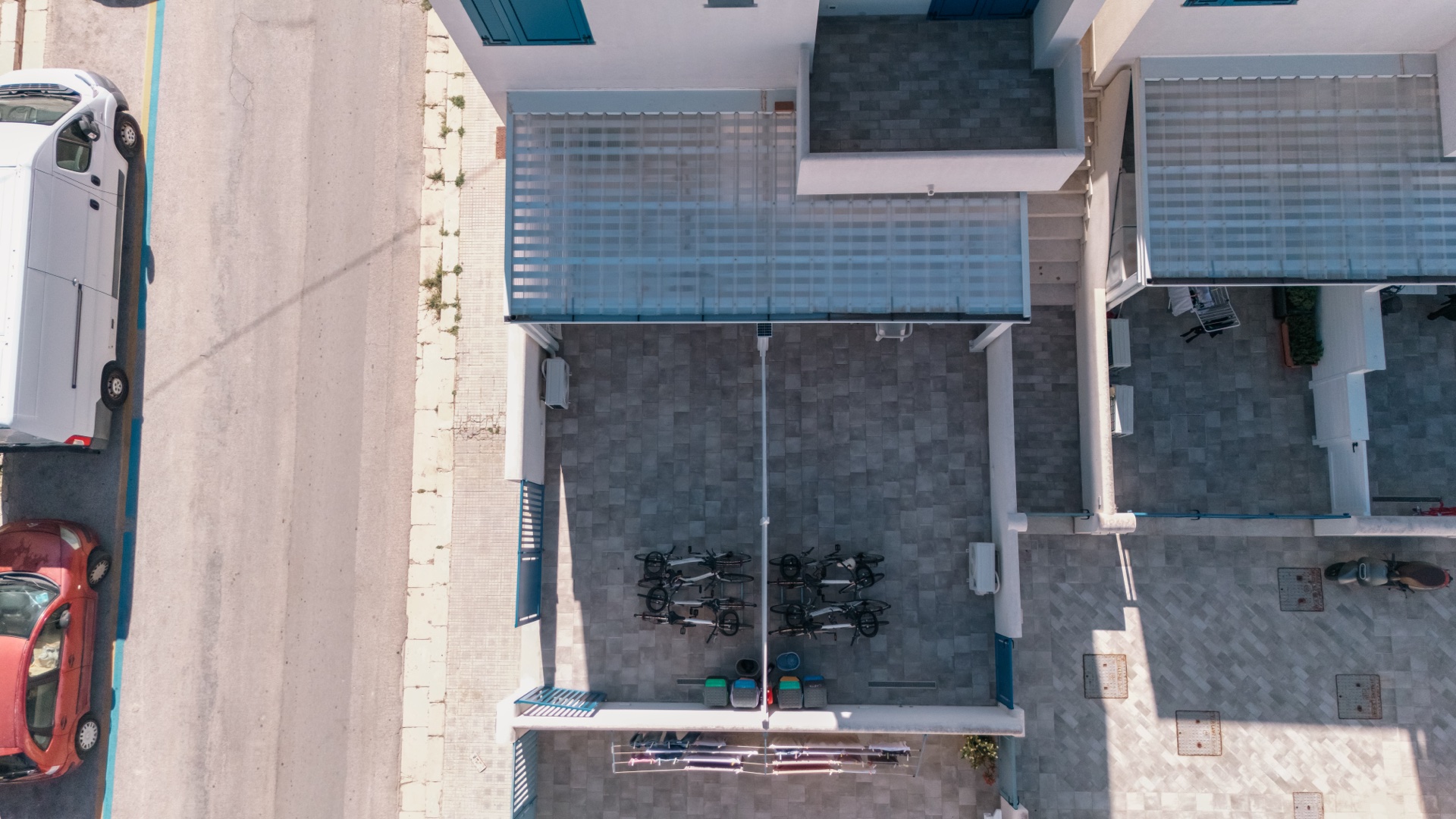 Vista verticale dall'alto del cortile con bici parcheggiate tra le due case