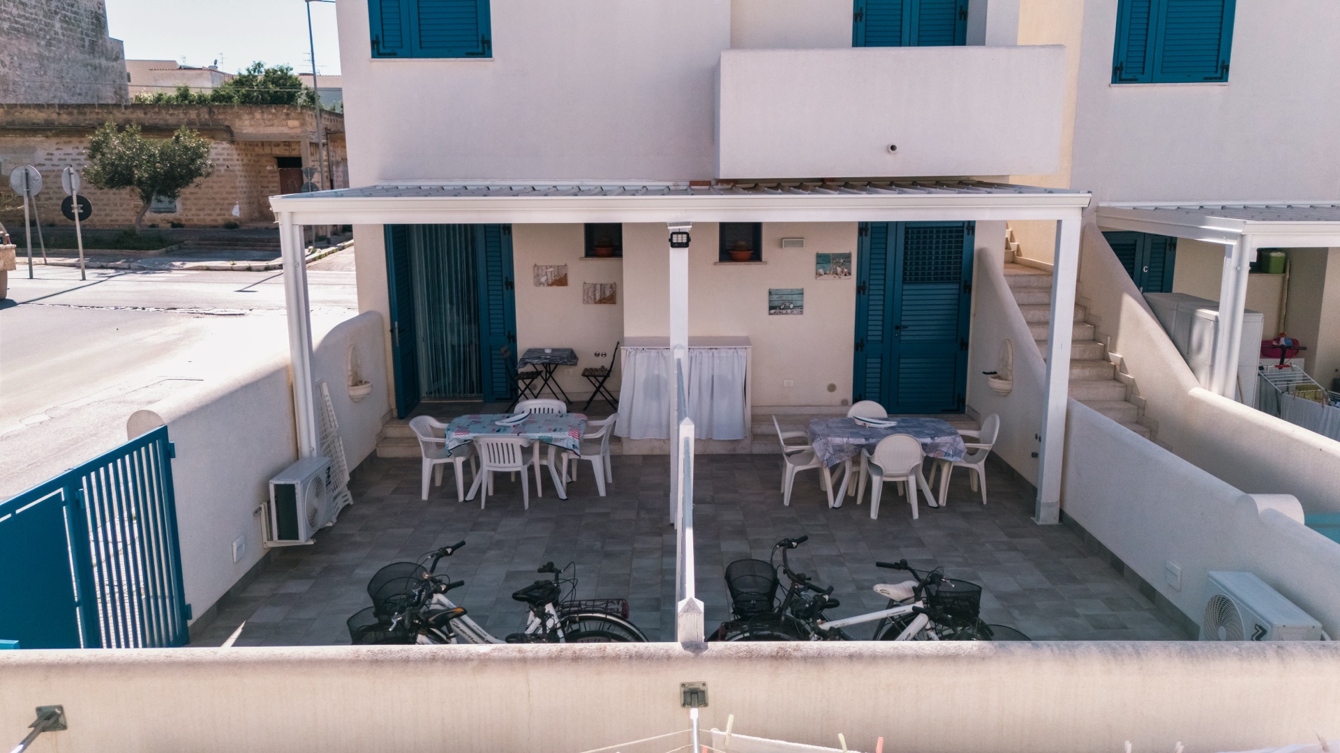 Vista frontale delle due verande di Holiday Asia con tavoli esterni e bici parcheggiate